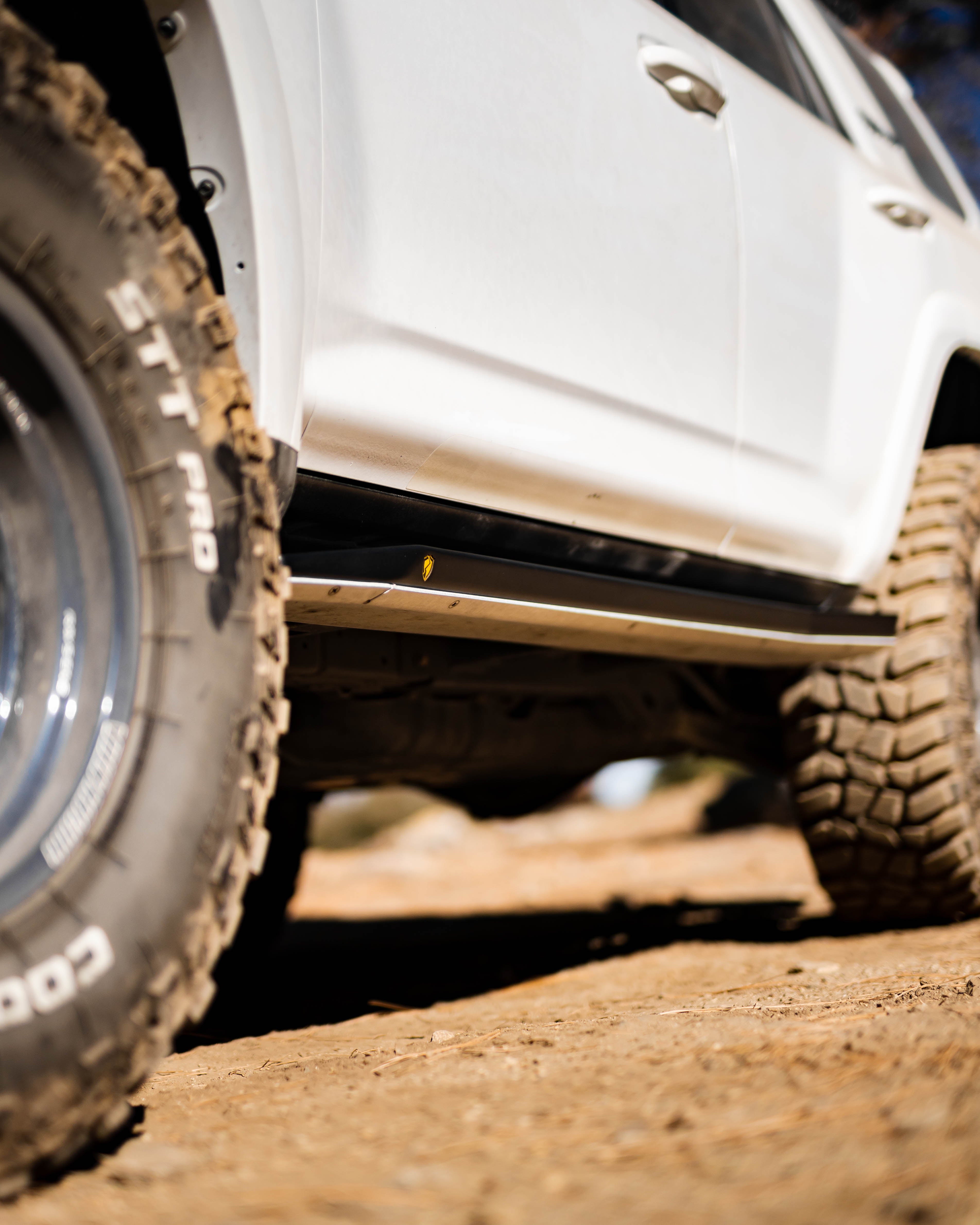 Low-angle view of Saints Offroad Toyota 4Runner rock slider and aluminum skid plate